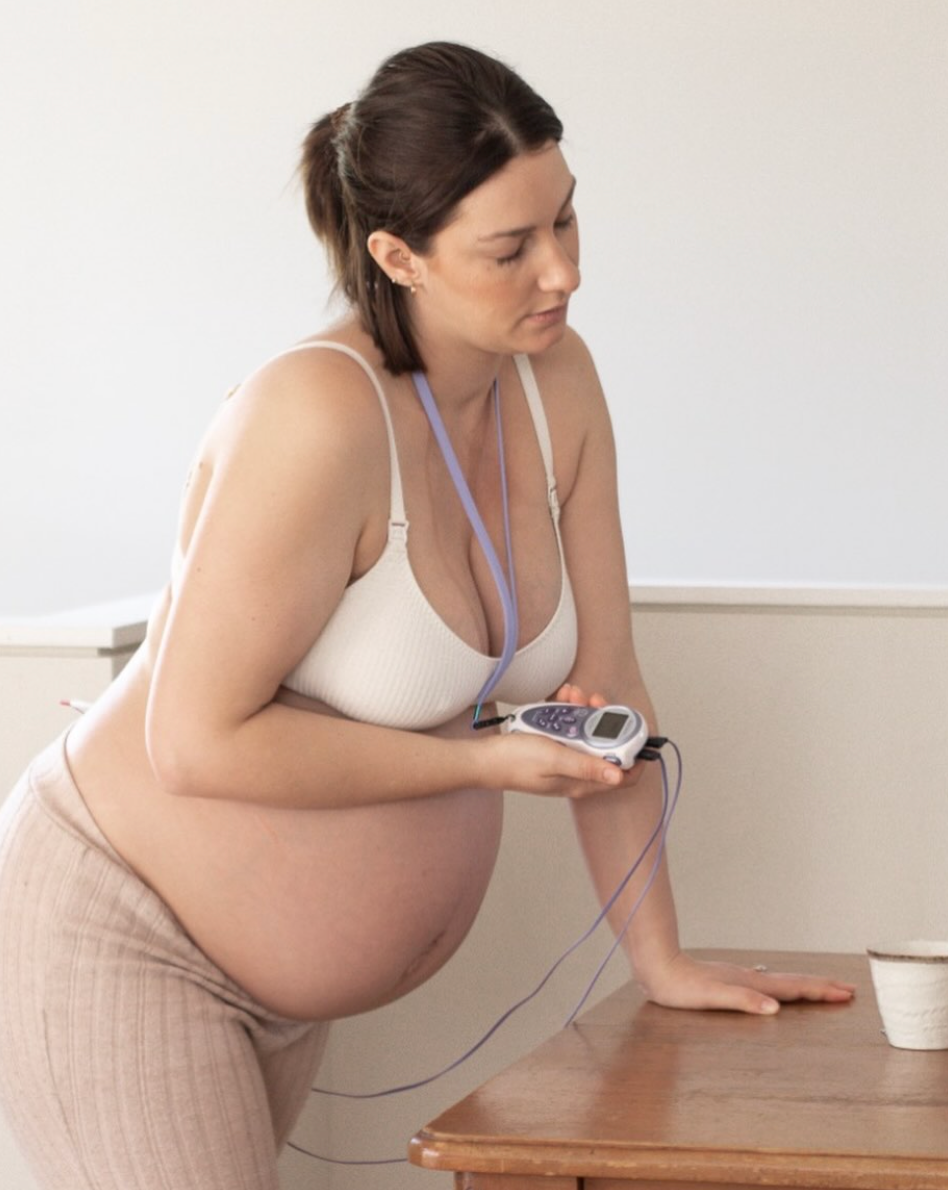 Pregnant woman using a TENS machine from a midwife on the sunshine coast